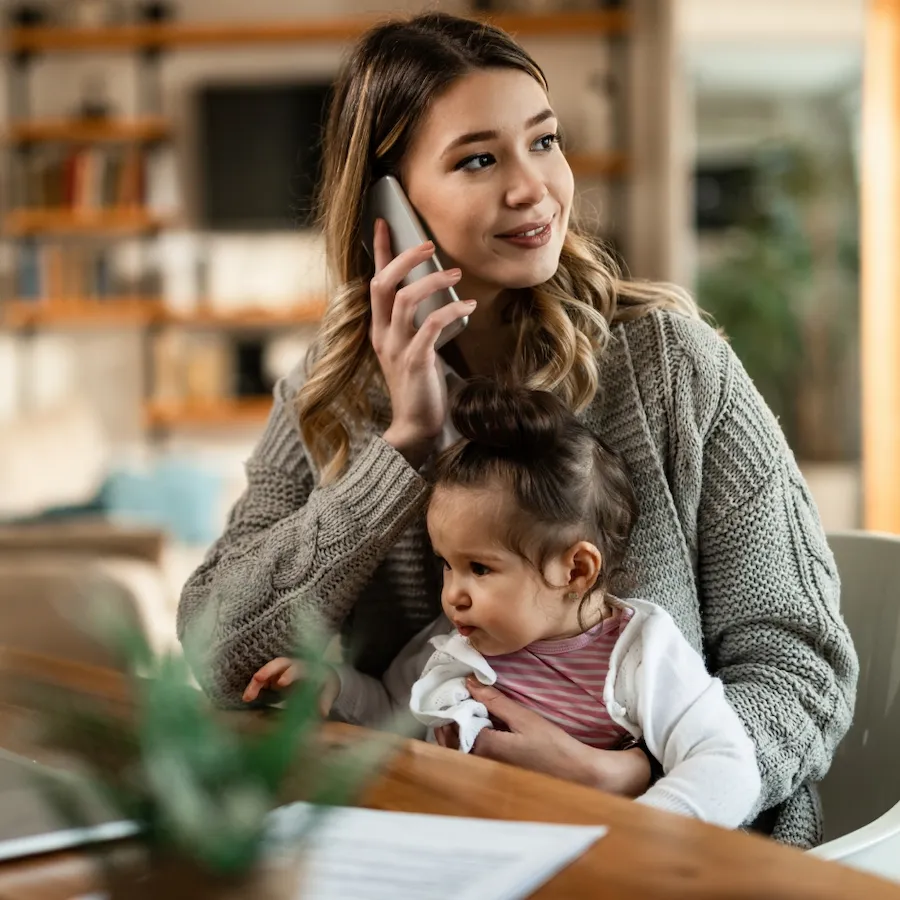 Parent on a phone call at home with family nearby