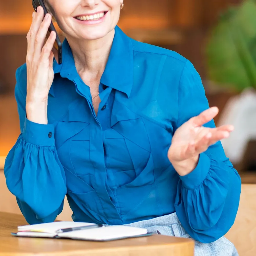 Person on a phone call with a government office, documents on the desk